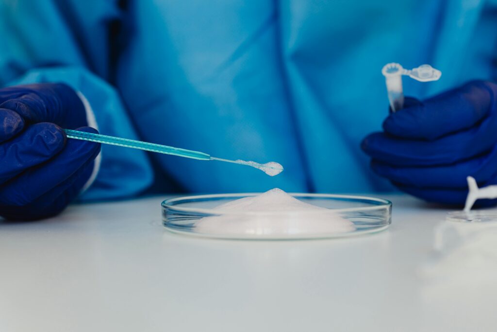 Close-up of a scientist conducting an experiment with a petri dish and blue pipette in a laboratory.